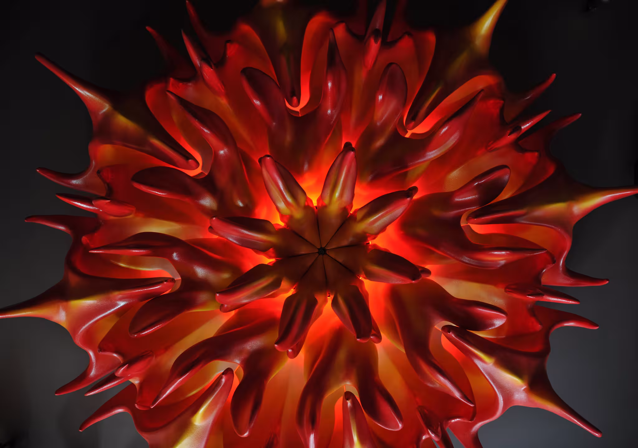 Detail of a custom red sculptural lighting fixture resembling flames, capturing the energetic and rebellious spirit of the rock-themed interior.