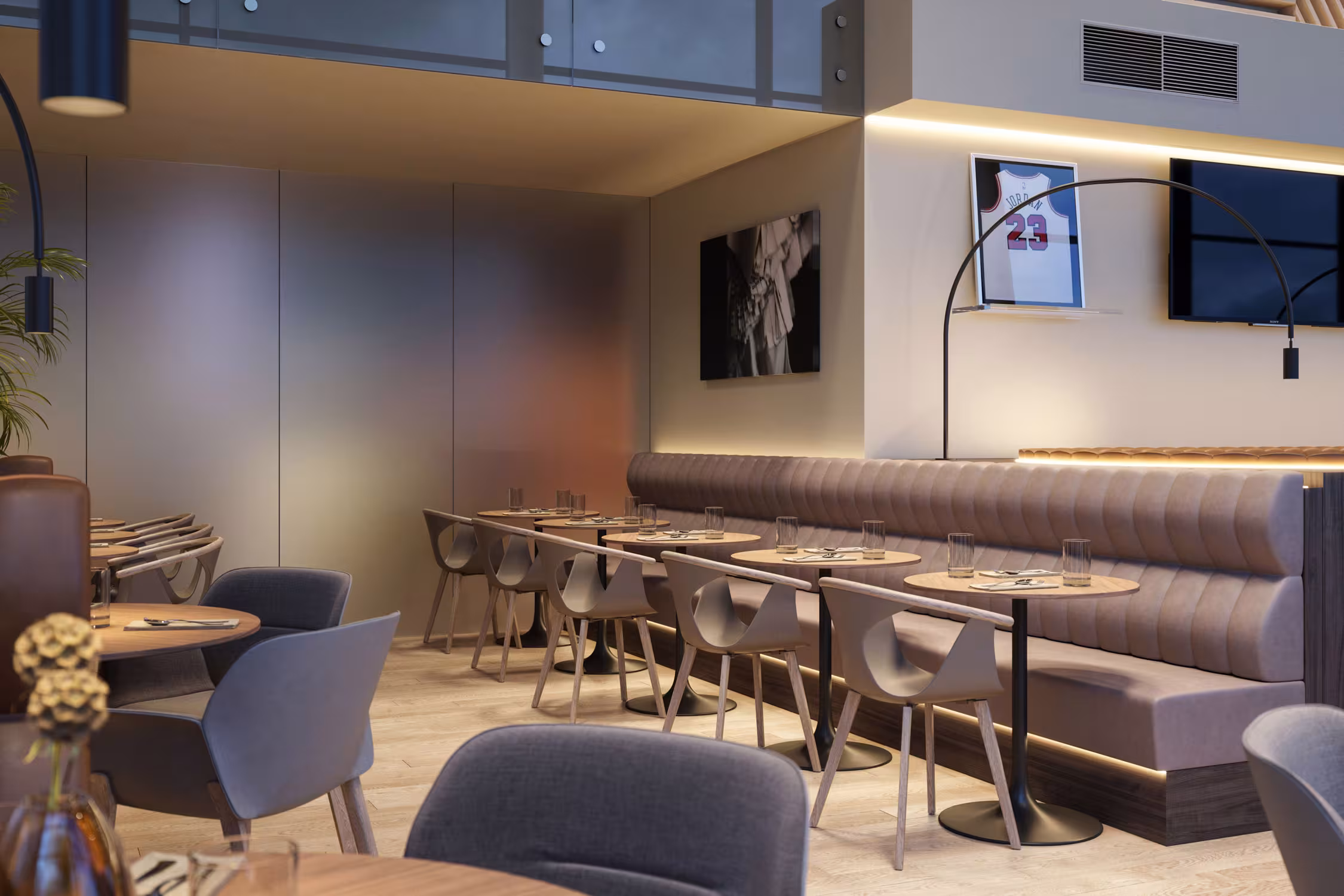 Hotel dining area featuring round wooden tables, modern grey armchairs and floor-to-ceiling sheer curtains that filter natural light.
