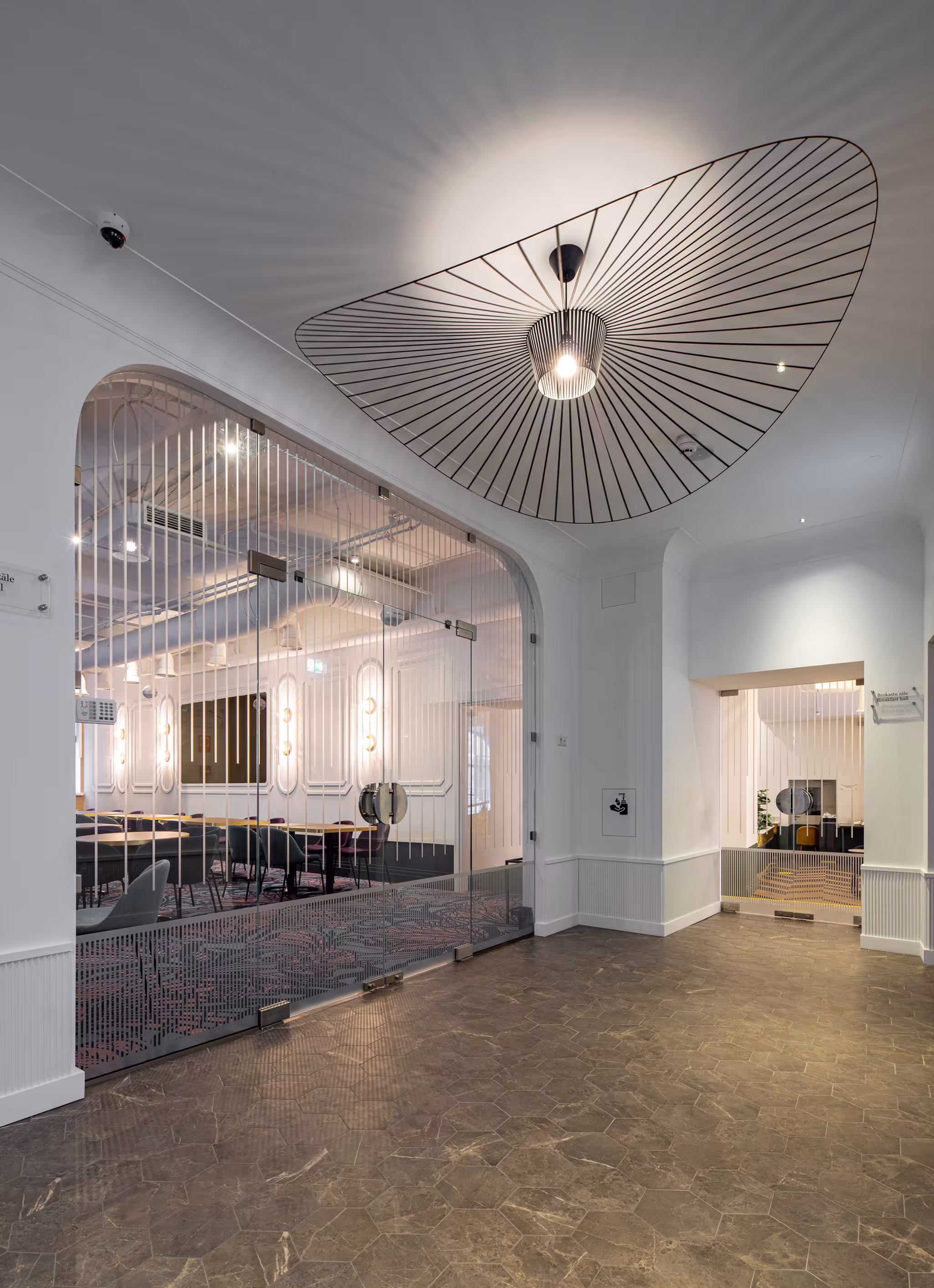 Riverside SPA Hotel's modern meeting room through glass, from a bright lobby with unique light.